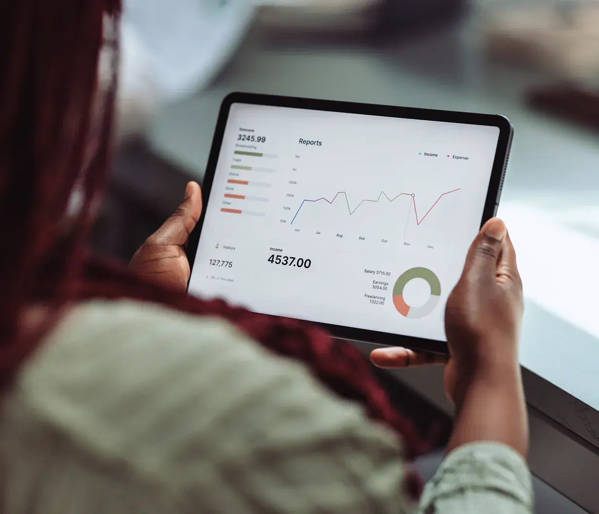 Person reviewing an analytics dashboard with charts on a tablet